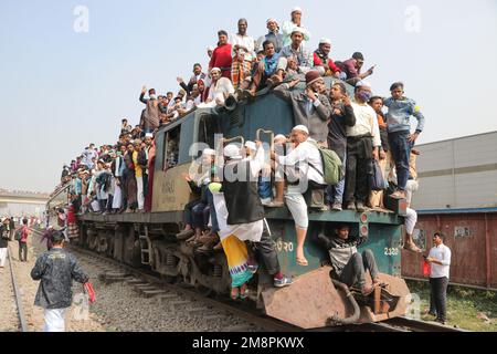 Dhaka, Dhaka, Bangladesch. 15. Januar 2023. Muslimische Anhänger reisen mit überfüllten, riskanten Zügen, nachdem sie das Akheri Munajat oder letzte Gebete besucht haben, in der Biswa Ijtema in Tongi, Dhaka, Bangladesch. Die Einheimischen nehmen die Reise in Angriff, klettern auf die Dächer von Lokomotiven und klettern sie an. Da im Inneren keine Sitzplätze verfügbar sind, entscheiden sich viele Pendler dafür, das Risiko einzugehen und eine Dachansicht für ihre Reise aus der Stadt Dhaka zu wählen.Millionen muslimischer Anhänger aus der ganzen Welt nehmen an dem viertägigen Event Teil, das im Akheri Munajat oder dem abschließenden Bitten gipfelt (Abschlussgebet) In welchem Mu Stockfoto