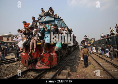 Dhaka, Dhaka, Bangladesch. 15. Januar 2023. Muslimische Anhänger reisen mit überfüllten, riskanten Zügen, nachdem sie das Akheri Munajat oder letzte Gebete besucht haben, in der Biswa Ijtema in Tongi, Dhaka, Bangladesch. Die Einheimischen nehmen die Reise in Angriff, klettern auf die Dächer von Lokomotiven und klettern sie an. Da im Inneren keine Sitzplätze verfügbar sind, entscheiden sich viele Pendler dafür, das Risiko einzugehen und eine Dachansicht für ihre Reise aus der Stadt Dhaka zu wählen.Millionen muslimischer Anhänger aus der ganzen Welt nehmen an dem viertägigen Event Teil, das im Akheri Munajat oder dem abschließenden Bitten gipfelt (Abschlussgebet) In welchem Mu Stockfoto