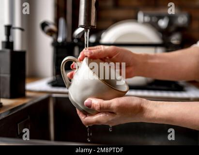 Mädchen, die den Becher mit Leitungswasser füllen Stockfoto