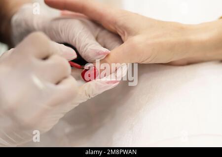 Maniküre mit rotem Nagellack auf Nägel Stockfoto