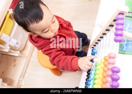 Kleine Jungs, die mit einem Abakus spielen Stockfoto