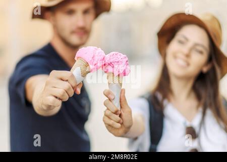 Glückliches Paar, das in Rom, Italien, Eis isst. Wunderschönes, helles Eis mit verschiedenen Geschmacksrichtungen in den Händen eines Paares Stockfoto