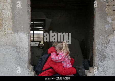 Mutter und Tochter in zerstörtem Gebäude. Krieg, Flüchtlinge, Kriegskrisenkonzept. Stockfoto