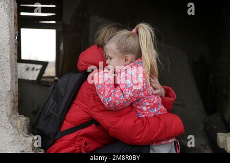 Mutter und Tochter in zerstörtem Gebäude. Krieg, Flüchtlinge, Kriegskrisenkonzept. Stockfoto