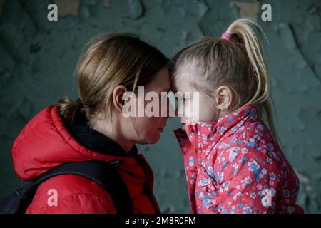 Mutter und Tochter in zerstörtem Gebäude. Krieg, Flüchtlinge, Kriegskrisenkonzept. Stockfoto
