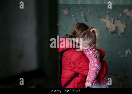 Mutter und Tochter in zerstörtem Gebäude. Krieg, Flüchtlinge, Kriegskrisenkonzept. Stockfoto