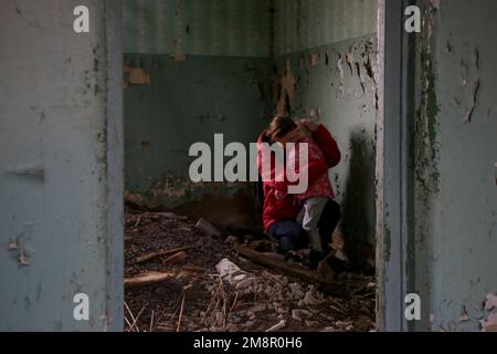 Mutter und Tochter in zerstörtem Gebäude. Krieg, Flüchtlinge, Kriegskrisenkonzept. Stockfoto