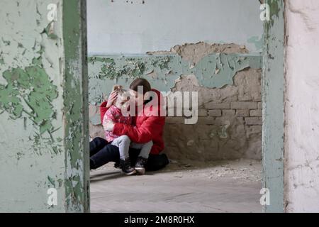Mutter und Tochter in zerstörtem Gebäude. Krieg, Flüchtlinge, Kriegskrisenkonzept. Stockfoto
