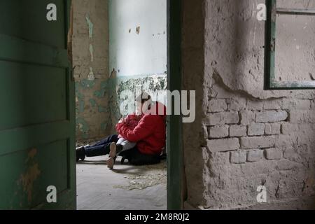 Mutter und Tochter in zerstörtem Gebäude. Krieg, Flüchtlinge, Kriegskrisenkonzept. Stockfoto