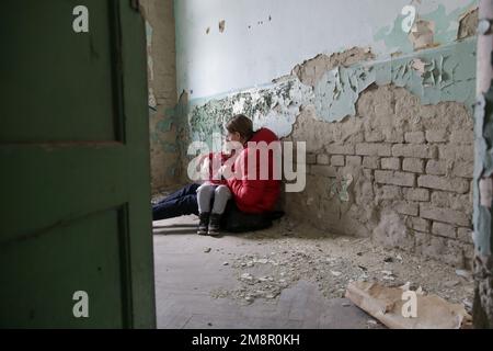 Mutter und Tochter in zerstörtem Gebäude. Krieg, Flüchtlinge, Kriegskrisenkonzept. Stockfoto
