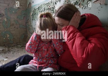 Mutter und Tochter in zerstörtem Gebäude. Krieg, Flüchtlinge, Kriegskrisenkonzept. Stockfoto