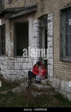 Mutter und Tochter in zerstörtem Gebäude. Krieg, Flüchtlinge, Kriegskrisenkonzept. Stockfoto