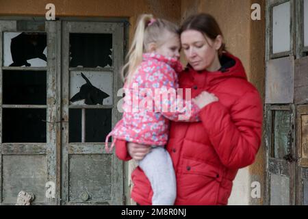 Mutter und Tochter in zerstörtem Gebäude. Krieg, Flüchtlinge, Kriegskrisenkonzept. Stockfoto