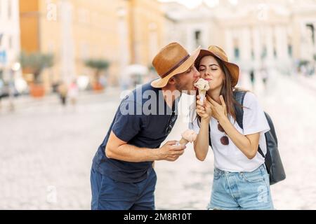 Glückliches Paar, das in Rom, Italien, Eis isst. Wunderschönes, helles Eis mit verschiedenen Geschmacksrichtungen in den Händen eines Paares Stockfoto