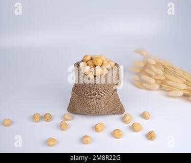 Nüsse in einem Stoffsack auf weißem Hintergrund. Stockfoto