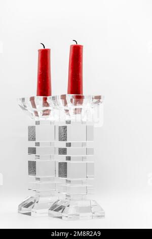 Nahaufnahme von zwei roten Kerzen in durchsichtigen, glasgeformten Kerzenhaltern Stockfoto