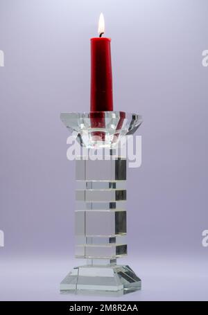 Nahaufnahme einer roten Kerze im durchsichtigen, glasgeformten Kerzenhalter Stockfoto