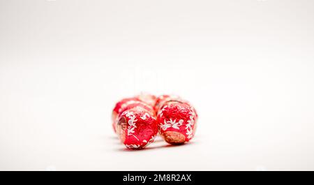 Nahaufnahme von mehreren mit roter Folie verpackten Süßigkeiten aus weihnachtsschokolade Stockfoto