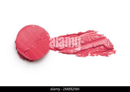 Make-up-Probe aus rotem Zementstein auf weißem Hintergrund. Dekorativer Kosmetikabstrich. Stockfoto