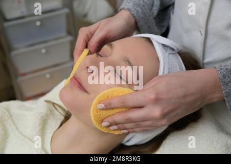 Dermatologe bereitet die Gesichtshaut der Frau für die Behandlung vor. Reinigungs-, Peeling- und Peeling-Prozess. Stockfoto