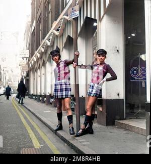 Ein Mann und eine Frau, die sich in identischen Outfits aus Pullover und Rock in der modischen Carnaby Street, London 1968, posieren. Nach der Produktion gefärbt. Foto von Tony Henshaw Archive Stockfoto