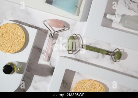 Rosenquarz und Jade-Gesichtswalze für Anti-Aging-Gesichtsmassage. Hautpflege Luxus-Kosmetikartikel. Stockfoto