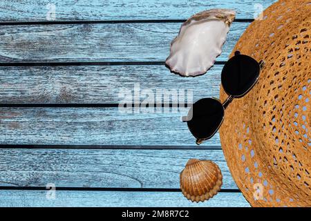 Banner für Werbekappen Brille Muscheln auf Holzhintergrund in blauer Farbe Stockfoto