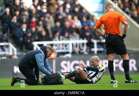 Bruno Guimaraes von Newcastle United wird wegen einer möglichen Verletzung behandelt, wie der Schiedsrichter Robert Jones während des Premier League-Spiels in St. James' Park, Newcastle. Foto: Sonntag, 15. Januar 2023. Stockfoto