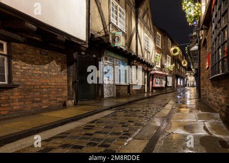 The Shambles, historische mittelalterliche Straße in York zur Weihnachtszeit mit nasser Kopfsteinpflasterstraße Stockfoto