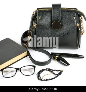 Elegantes Set von Accessoire für Frauen. Tasche, Brille, Buch, Kosmetik und Perlen isoliert auf weißem Hintergrund Stockfoto