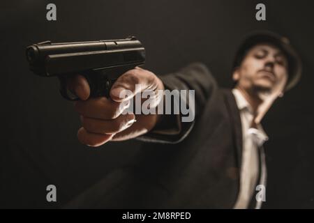 Ein alter Gangster mit einer Waffe in der Hand Stockfoto