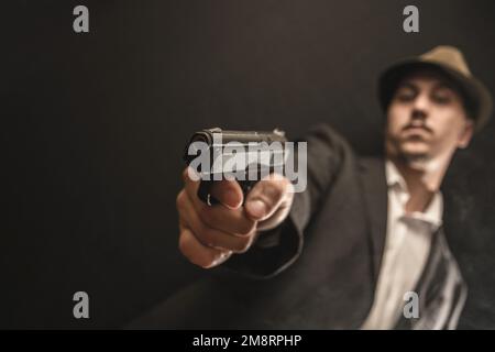 Ein alter Gangster mit einer Waffe in der Hand Stockfoto