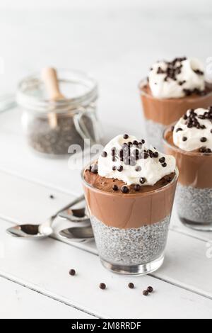 Schokoladen-Chia-Pudding-Tassen, garniert mit Schokoladen-Quinoa-Puffs. Stockfoto