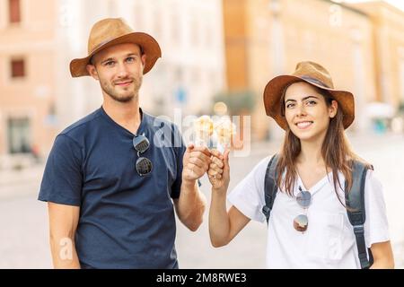 Glückliches Paar, das in Rom, Italien, Eis isst. Wunderschönes, helles Eis mit verschiedenen Geschmacksrichtungen in den Händen eines Paares Stockfoto
