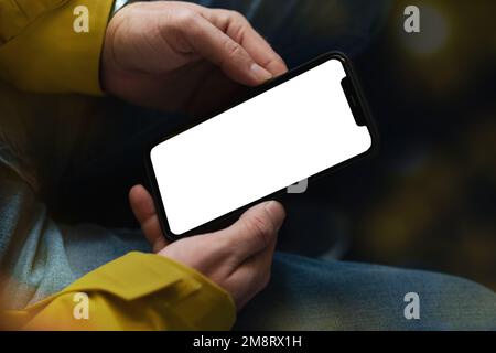 Weißer, leerer Bildschirm des Smartphones in Nahaufnahme der männlichen Hände. Stockfoto