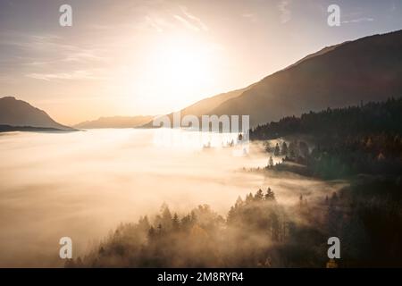 Moody Clouds während des Sonnenaufgangs im Herbst in Kärnten. Panoramablick auf die Berge in den Alpen. Stockfoto