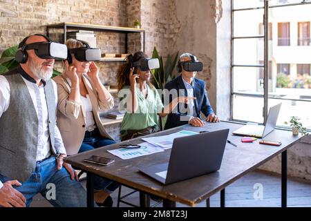 Kreative multiethnische Teamarbeit mit Hightech-Headsets für virtuelle Realität, modernes und futuristisches Gerät für die Planung und Entwicklung von Geschäfts- und Strategieplanung, Stockfoto