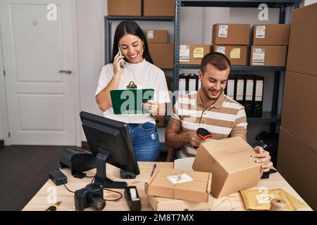 Männer und Frauen, die im Geschäft mit dem Smartphone sprechen und das Etikett mit einem Barcode-Lesegerät scannen Stockfoto