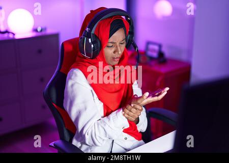 Junge schöne Frau Streamer gestresst mit Computer im Spielzimmer Stockfoto