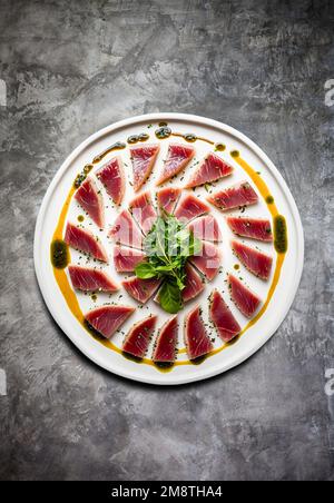 Ein Teller mit mariniertem Thunfischsteak in Scheiben. Stockfoto