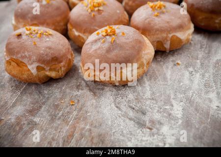 Fat Thursday. Fotos von Donuts mit Kirschfüllung und Glasur. Donuts auf rustikalem Hintergrund. Stockfoto