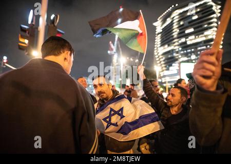 Tel Aviv, Israel. 14. Januar 2023. Israelische Friedensaktivisten halten Palästina- und Israel-Flaggen, nachdem bei den Protesten der vergangenen Woche große Kritik am Wenden palästinensischer Flaggen geübt wurde. Mehr als 80.000 Menschen protestierten in Tel Aviv gegen Netanjahus rechtsextremen Regierungs- und Justizüberholung. Kredit: SOPA Images Limited/Alamy Live News Stockfoto