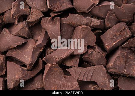 Zerbrochene Riegel, dunkler Schokoladenhintergrund, Nachspeise Stockfoto