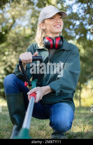 Junge Frau mäht das Gras Stockfoto