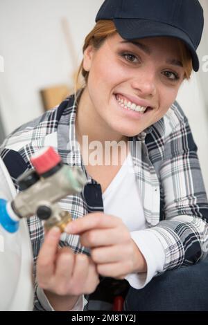 Glückliche und aufgeregte junge Klempnerin Stockfoto