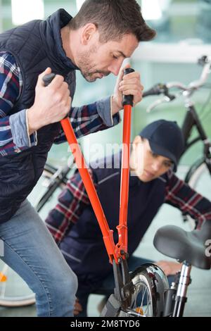 Mann mit Bolzenschneider auf einem Fahrrad Stockfoto