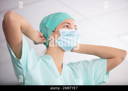 Eine Krankenschwester, die eine Maske aufsetzt Stockfoto