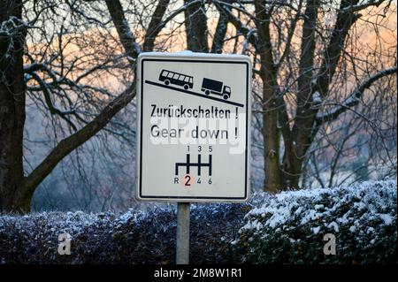 Ein Straßenschild, das schwere Fahrzeuge darauf hinweist, aufgrund einer steilen Straße herunterzuschalten oder herunterzuschalten Stockfoto