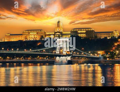 Malerischer Blick auf die Kettenbrücke und die Burg Buda (Königlicher Palast) in Budapest auf der Donau am Abend. Ungarn. Stockfoto