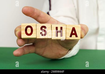 In der Hand des Mannes sind Würfel mit der Inschrift OSHA. Stockfoto